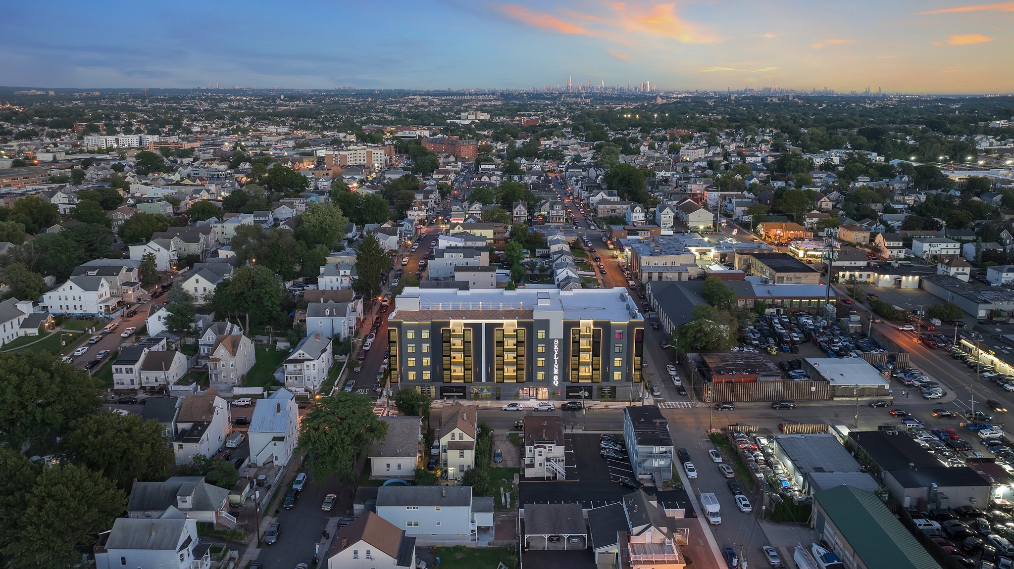 A wide shot of Skyline Square during sunset with NYC peeking in the background